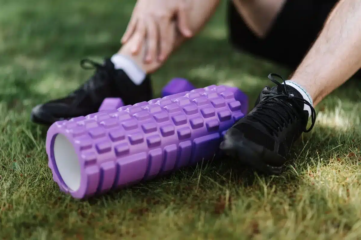 Persona che usa il foam roller sulla gamba con movimenti controllati e postura corretta.