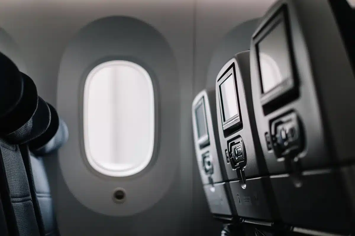 Passeggero in aereo beve acqua durante il volo per mantenersi idratato