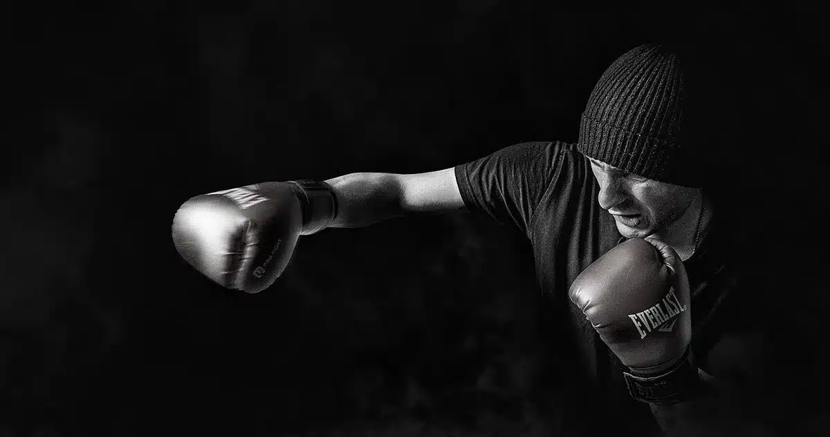 Mano anonima che impugna un kettlebell in una palestra luminosa
