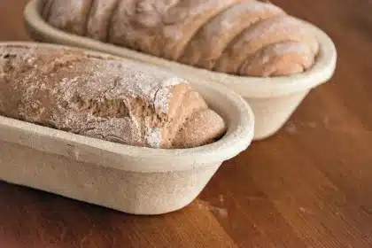 Tavolo con piatto unico bilanciato di cereali integrali, legumi e verdure, mani anonime