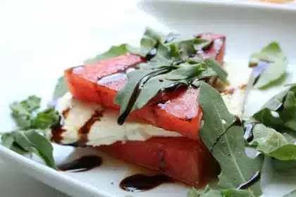 Piatto estivo con feta sbriciolata, pomodori, olive e erbe aromatiche in stile mediterraneo
