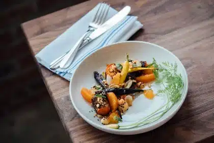 Piatto di gamberi con verdure e limone su tavola informale