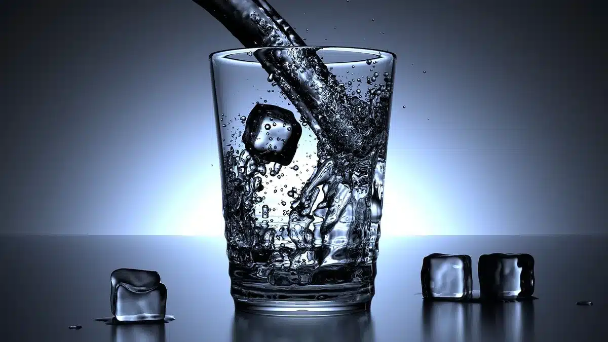Donna che beve acqua per favorire l'idratazione e ridurre la ritenzione idrica