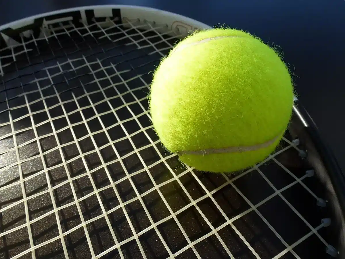 Bordo campo da tennis con racchetta e ginocchiera appoggiate, luce soft