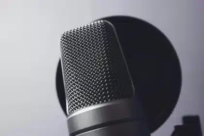 Silhouette di persone che parlano vicino a microfoni e registratori in ambiente clinico informale